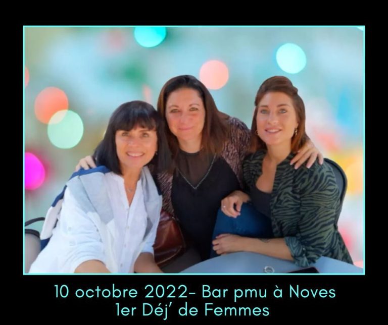Trois femmes souriantes posent ensemble dans un décor flou aux lumières colorées.