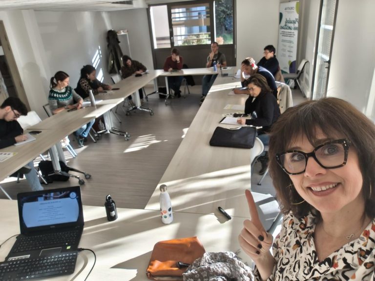 Nikolina Popovski, coach en vente, explique un sujet devant un public attentif en salle de réunion.