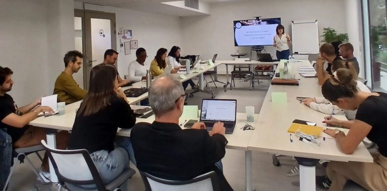 Groupe de personnes assises en cercle lors d'une discussion, avec un intervenant au centre.