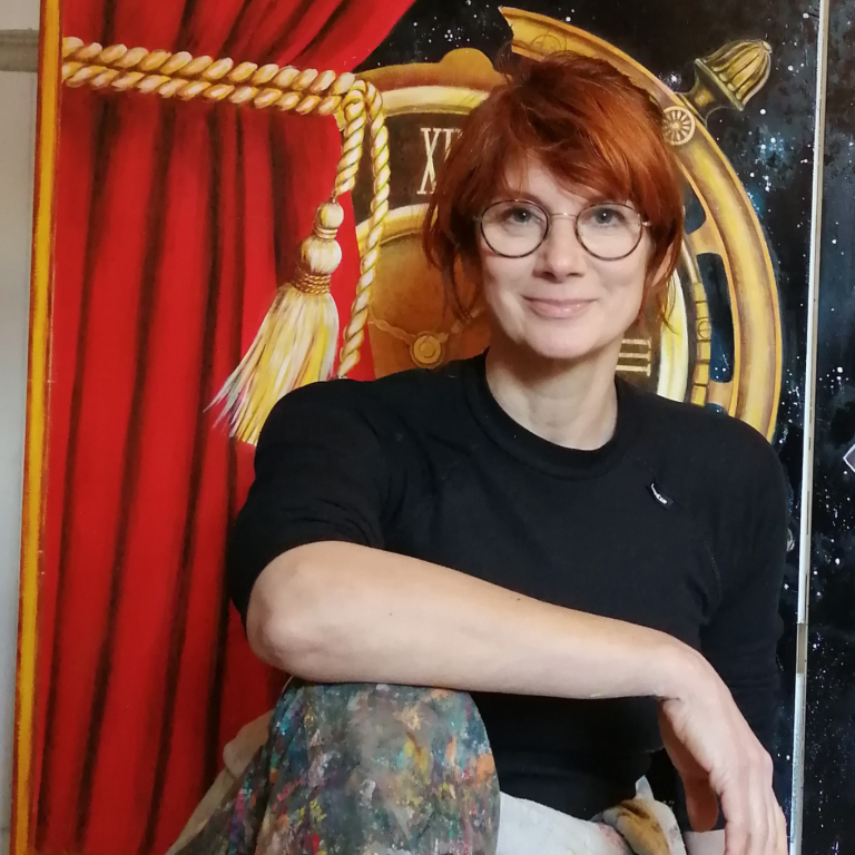 Femme souriante portant des lunettes, vêtue d'un haut noir, avec un fond artistique.