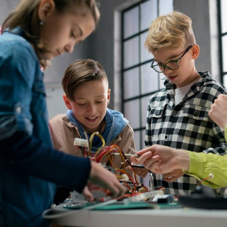 Enfants manipulant des câbles et des composants électroniques lors d'une activité.
