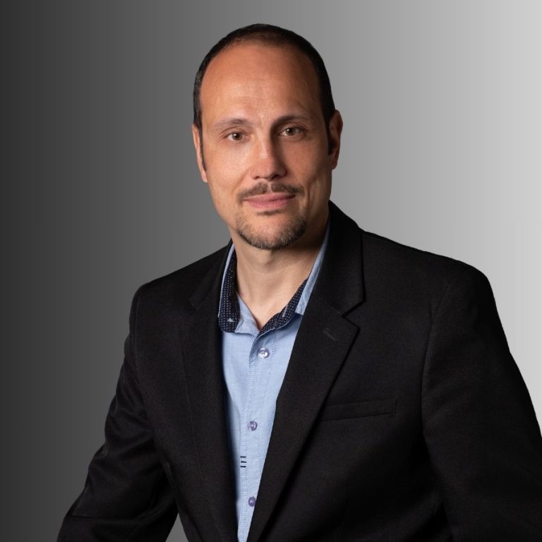 Femme souriante portant des lunettes, vêtue d'un haut noir, avec un fond artistique.