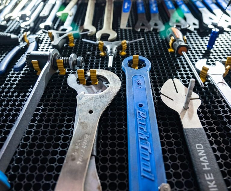 Services du Quotidien by Polymathia Group Un assortiment d'outils en métal et en plastique sur un support noir.