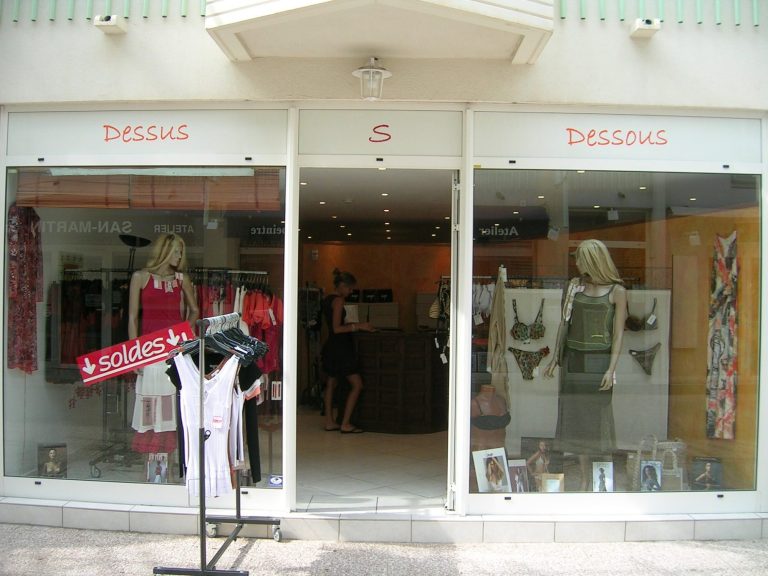 Boutique de vêtements avec des mannequins et des articles exposés en vitrine.