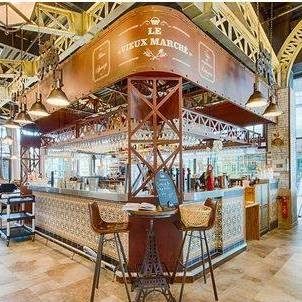 Julien Liogier - Le vieux Marché Bar à tapas avec comptoir, chaises hautes et décor rustique.