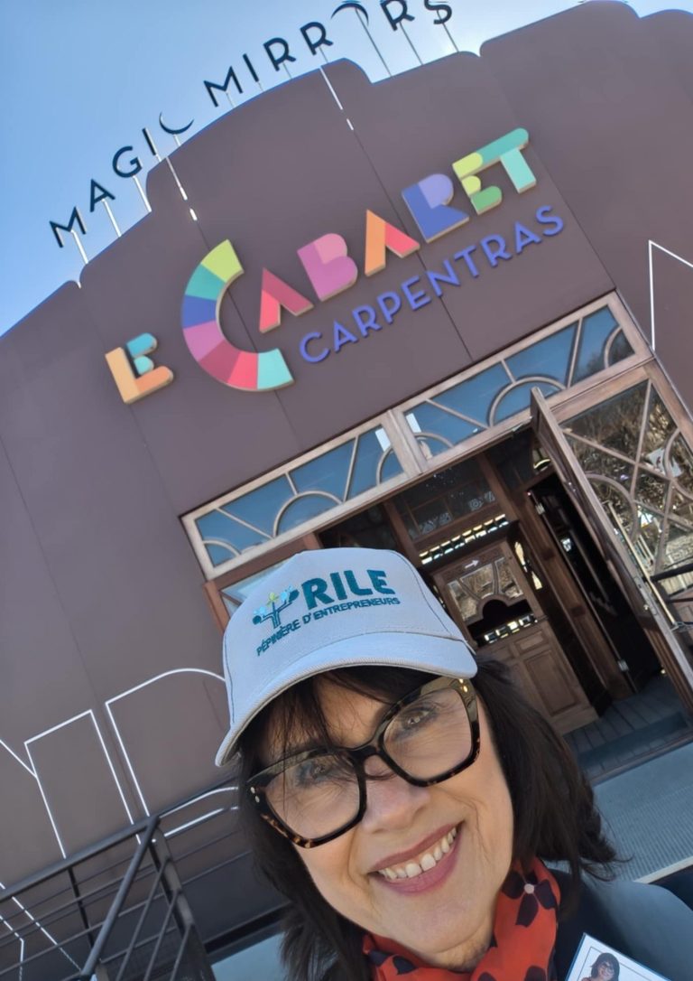 Nikolina Popovski souriante devant l'entrée du Cabaret à Carpentras, portant une casquette.