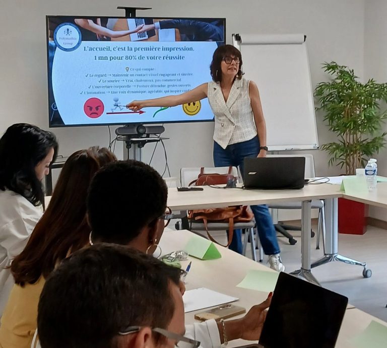 Nikolina Popovski, coach en vente, explique un sujet devant un public attentif en salle de réunion.