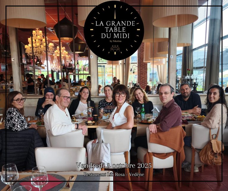 Groupe de personnes souriantes autour d'une table dans un restaurant élégant.