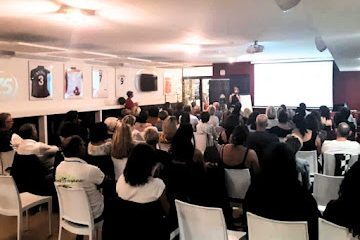 Salle comble avec des participants attentifs lors d'une présentation de Nikolina Popovski